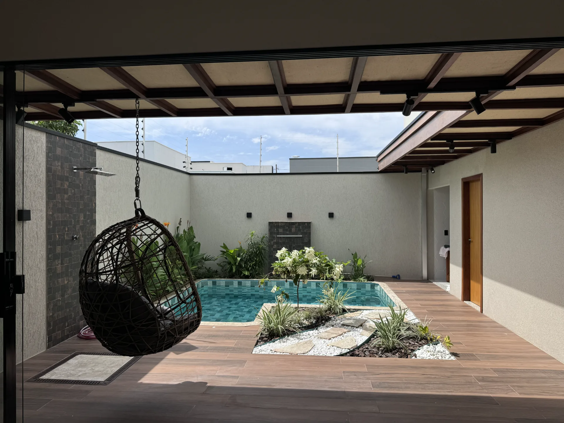 Piscina integrada ao jardim e ao deck da residência